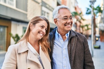 Poster - Middle age man and woman couple smiling confident standing together at street