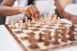 © Krakenimages.com - African american woman playing chess game sitting on table at home