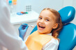 © VisualProduction - Little girl visiting dentist office. Smiling girl in dentist chair. Children's doctor, healthcare. Generative AI