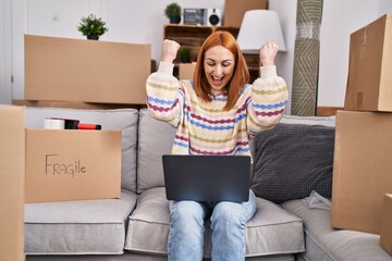 Poster - Young caucasian woman using laptop with cheerful expression at new home