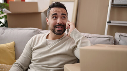 Sticker - Young hispanic man smiling confident talking on smartphone at new home