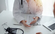 © rogerphoto - Doctor and patient discussing current health questions while sitting at the desk in clinic office, closeup. Medicine and healthcare concept.