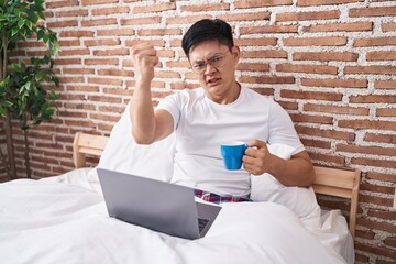 Sticker - Young asian man drinking coffee sitting on the bed annoyed and frustrated shouting with anger, yelling crazy with anger and hand raised