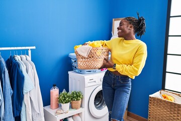 Sticker - African american woman smiing confident holding basket with clothes at laundry room
