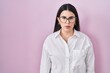 © Krakenimages.com - Young brunette woman standing over pink background relaxed with serious expression on face. simple and natural looking at the camera.