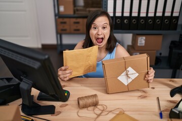 Poster - Hispanic girl with down syndrome working at small business ecommerce celebrating crazy and amazed for success with open eyes screaming excited.