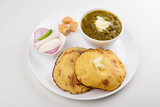 Fototapeta Dinusie - Sarson saag with corn chapati served with white makhan and jaggery in plate isolated on white background