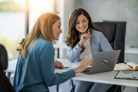 Business women working together on computer in modern office