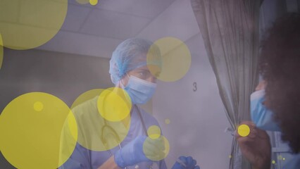 Sticker - Animation of yellow spots over caucasian female doctor in face mask with swab and female patient