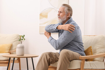 Sticker - Senior man suffering from pain in his elbow at home. Arthritis symptoms