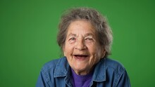 Closeup Portrait Of Toothless Elderly Senior Old Woman With Wrinkled Skin And Grey Hair Getting Great Happy With Success Winner Isolated On Green Screen Background. Emotions Concept