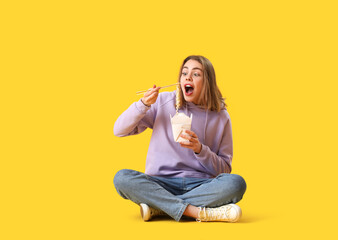 Sticker - Young woman eating Chinese noodles on yellow background