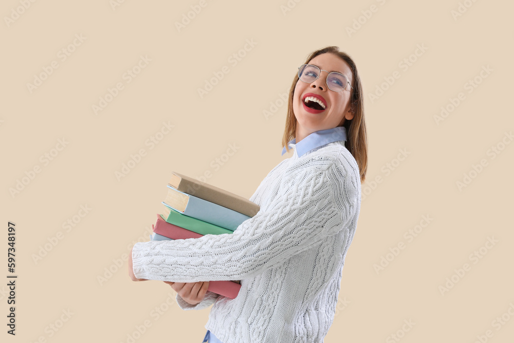 Young woman with books on beige background