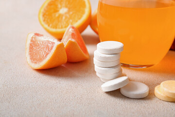 Vitamin C effervescent tablets and fruits on grey grunge table