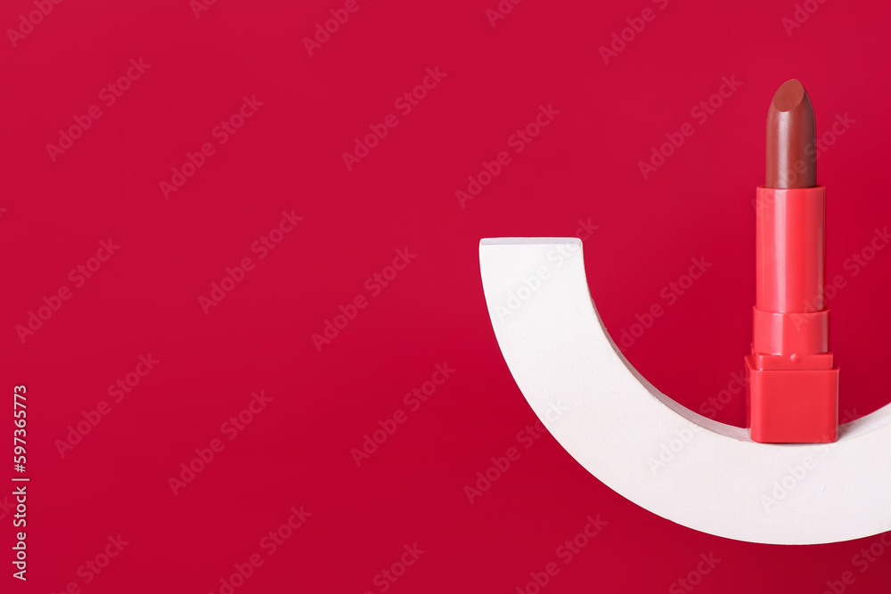 Decorative plaster podium and lipstick on red background