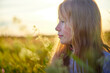 © keleny - Portrait of pretty blonde girl having fun in a meadow on a natural landscape with grass and flowers on a sunny summer day. Portrait of a teenage child in summer or spring outdoors on field