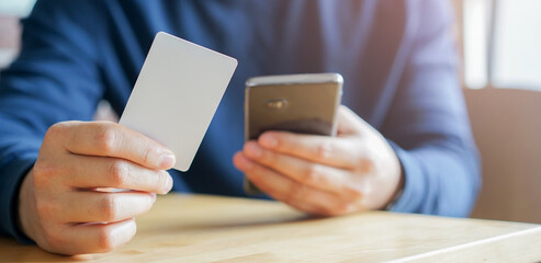 close up young man hand hold credit card after buy item on website and waiting for payment about OTP message from smartphone for people lifestyle and technology concept