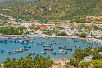 Wall Mural - Distant view of a fleet of fishing boats on the harbour of a coastal village at Vinh Hy Bay in Vietnam