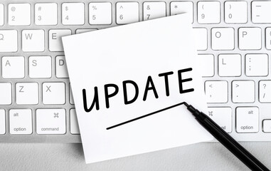 Poster - White paper with text Update lying on the keyboard