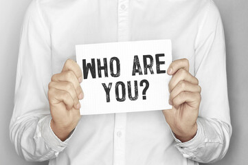 Poster - Man holding a paper card with text Who are you