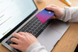 © Studio Marmellata - Crop anonymous female hand holding a credit card, doing online shopping on computer