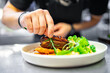 © pavel siamionov - chef hand cooking Roasted Duck breast fillets with vegetable salad and batat in plate on restaurant kitchen