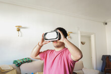 Man In VR Headset Playing Video Game At Home