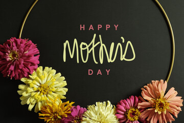 Wall Mural - Zinnia flowers on black background with mothers day greeting.