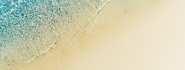 sunny abstract sand beach with transparent clear water from above, natural beach background concept 