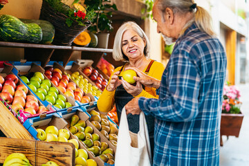 Wall Mural - Senior man buying fresh fruits at the market - Shopping food concept