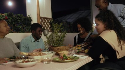 Wall Mural - Family dinner: Happy African American people dining together at home terrace outdoors - Healthy food lifestyle