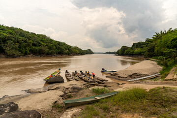 Wall Mural - Rocks, amazonian river, boats and jungle in the area of colombian amazon