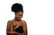 © Edson Souza - a woman applying moisturizing cream to her skin, smiling while holding a bottle demonstrating skin care