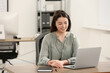 © New Africa - Hotline operator with headset working on laptop in office