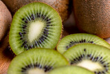 Fototapeta Tęcza - A group of cut green kiwi fruits with black seeds