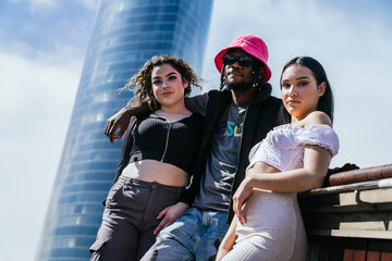 Captivating Diversity: Three Expressive Youth in Modern Street Attire, African Guy Holding Two Latina Girls