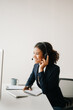 © Nuttapong punna - Serious call center operator in wireless headset talking with customer, woman in headphones with microphone consulting client on phone in customer support service in business center