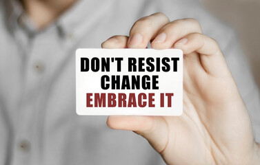 Poster - Card with text Do not resist change embrace it in a man's hand