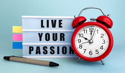 Poster - text live your passion written on the lightbox with alarm clock and colorfull stickers on blue backg