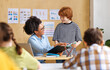 © JenkoAtaman - African american teacher smiling and looking at student    in class during lesson