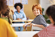 © JenkoAtaman - Cheerful redhead teen boy smiling at camera during lesson  in class