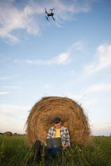 Fototapete - Farmer with laptop and drone on the field. Smart farming and agriculture digitalization	