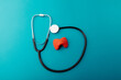 Anatomical model of thyroid and stethoscope on blue background