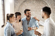 © Goran - Happy business colleagues talking while drinking alcohol on a party in the office