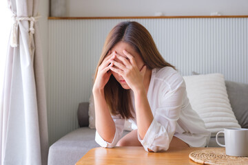 Wall Mural - A young woman feeling sad and stressed, sick and headache at home