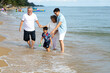 © NVB Stocker - Happy asian family spending time together on the beach summer vacation.
