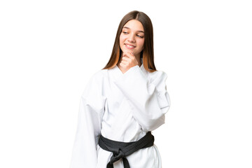 Sticker - Teenager girl doing karate over isolated chroma key background looking to the side and smiling