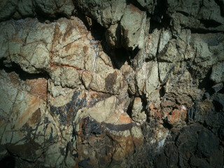 Cracked rock texture.. brown rock texture with cracks. Close-up. Rough mountain surface. Stone granite background. rock wall backdrop with rough texture. Abstract, grungy and textured surface