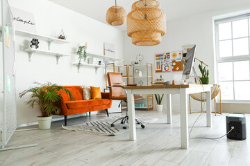 Interior of office with graphic designer's workplace, shelves and sofa