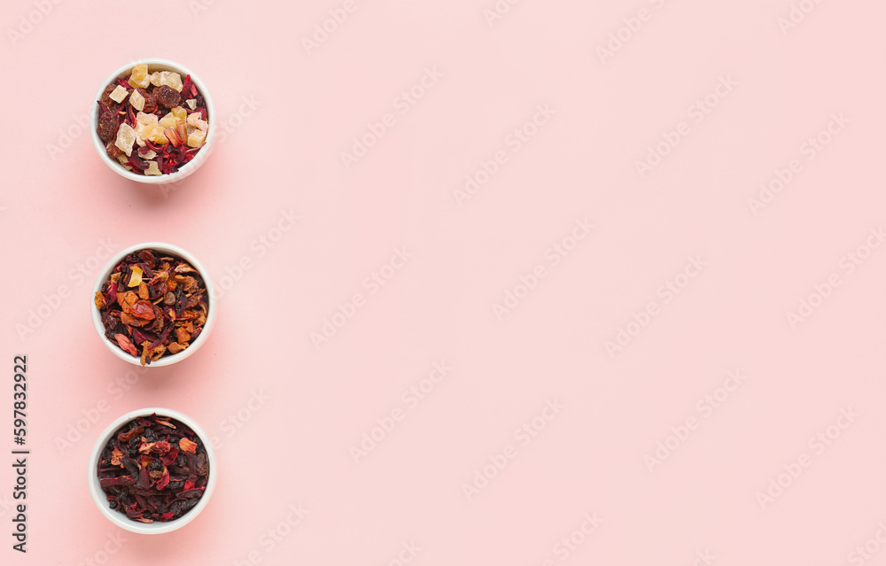 Bowls with different dried fruit tea on pink background